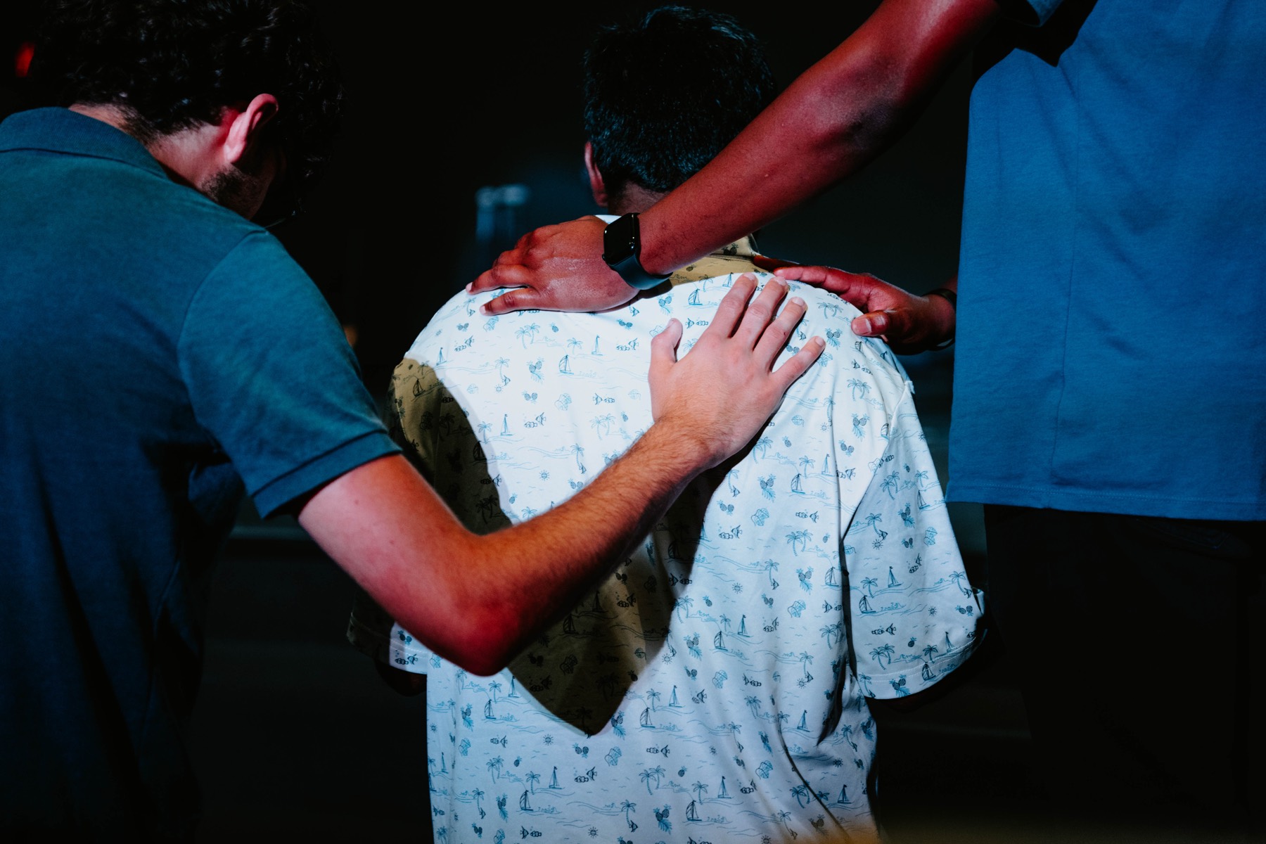 Students praying together with hands on shoulders